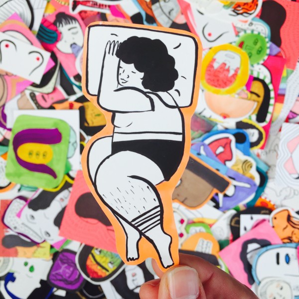 Pile of stickers. Central sticker is  woman sleeping with orange border. 