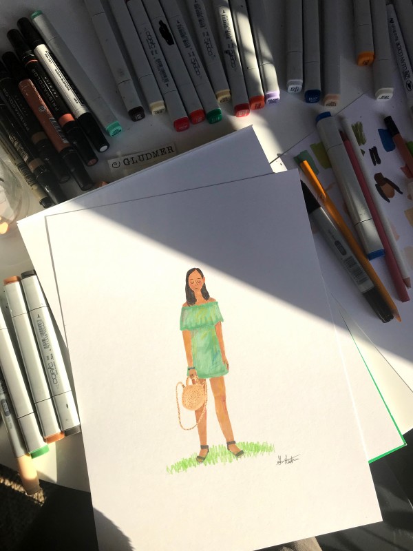 Markers surrounding drawing of girl wearing strapless light green dress holding wicker bag.