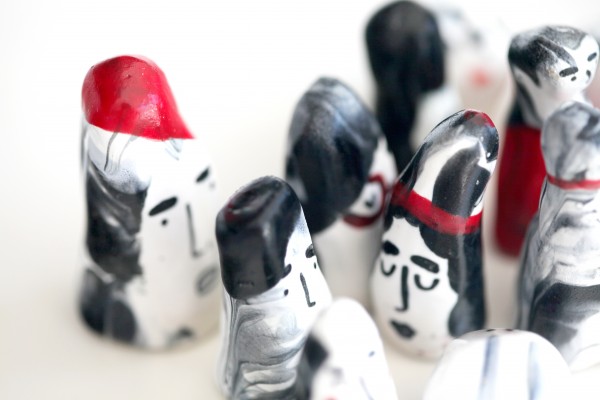 Collection of porcelain heads grouped together in cluster on white background. 