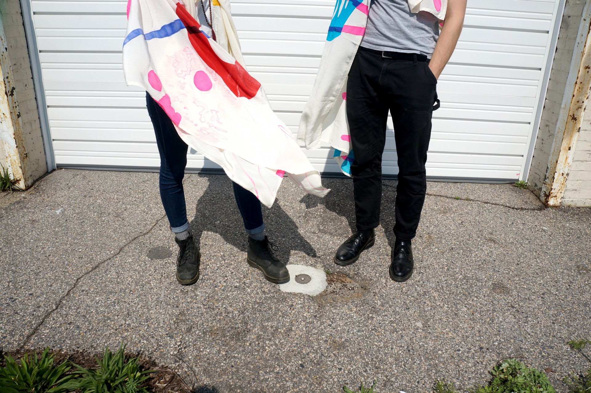 Bottom half of two models draped in scarves. 