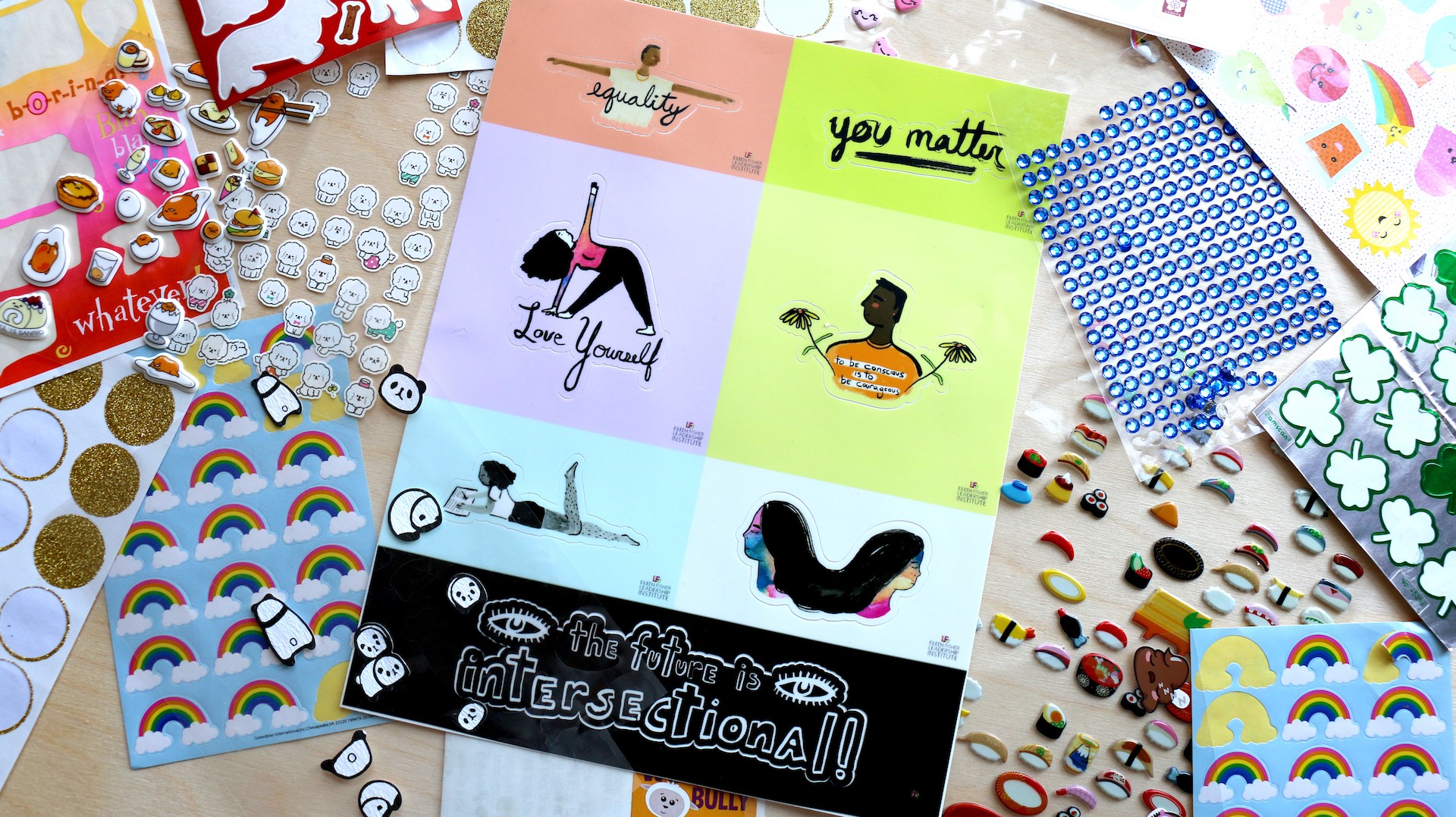 Various sticker sheets spread on wooden table.
