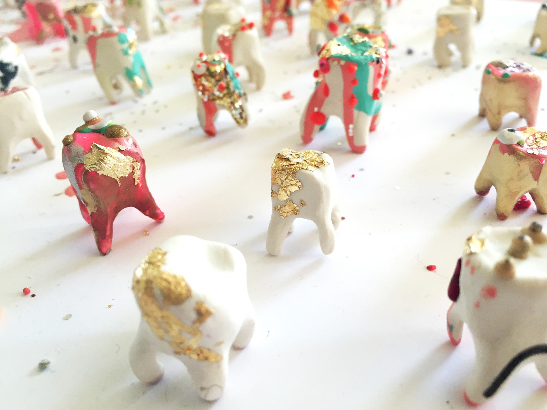 A collection of white clay teeth with marker and melted wax. Close up of a few teeth on white surface. 