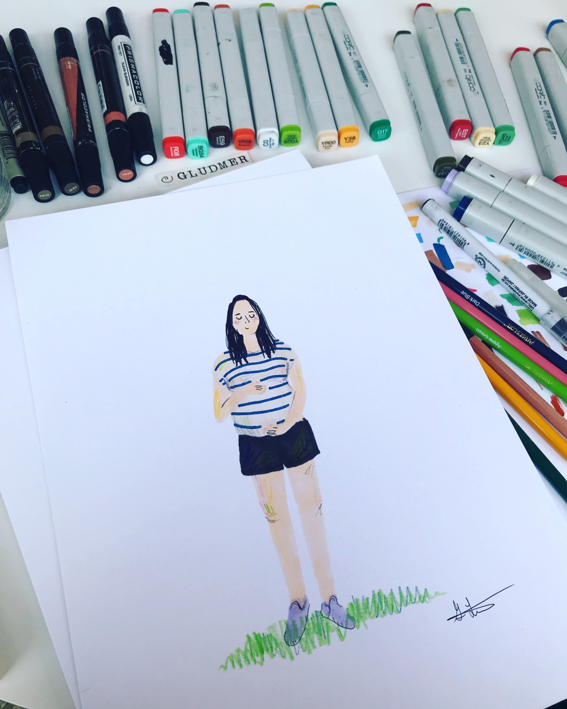 Markers surrounding portrait of pregnant woman wearing striped shirt and black shorts. 