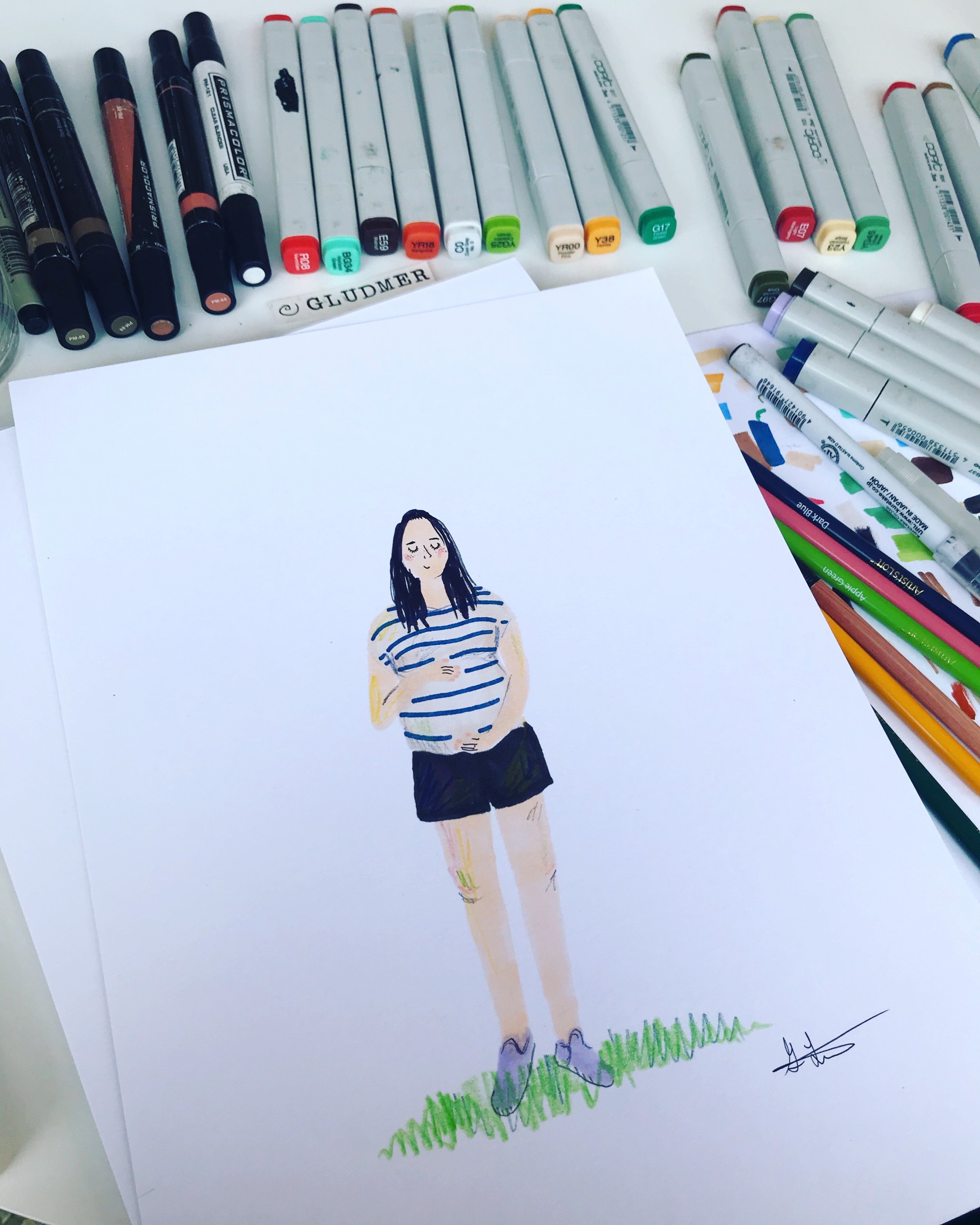 Markers surrounding portrait of pregnant woman wearing striped shirt and black shorts.