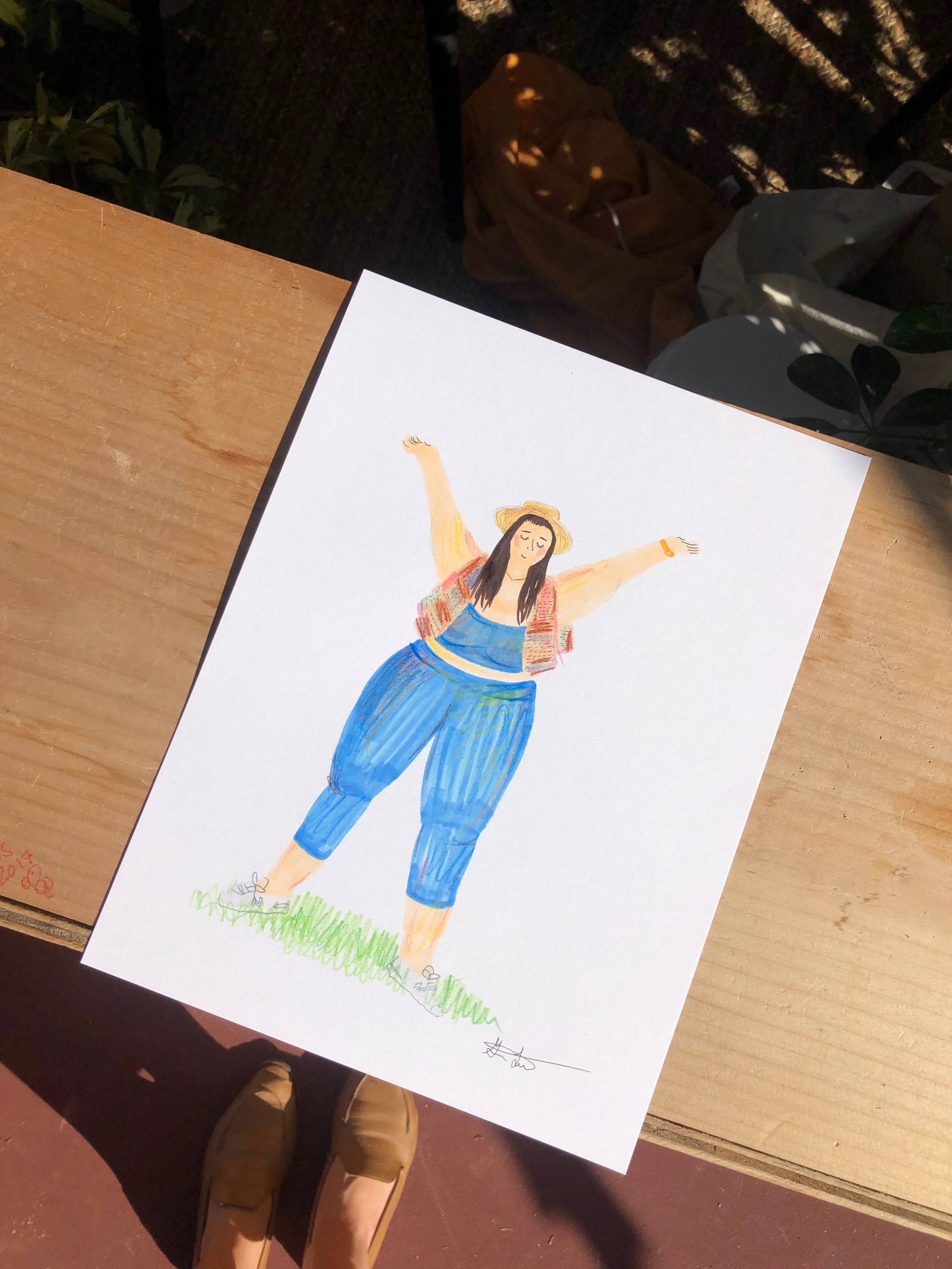 Drawing of girl in blue leggings and blue sports bra with hands above head. 