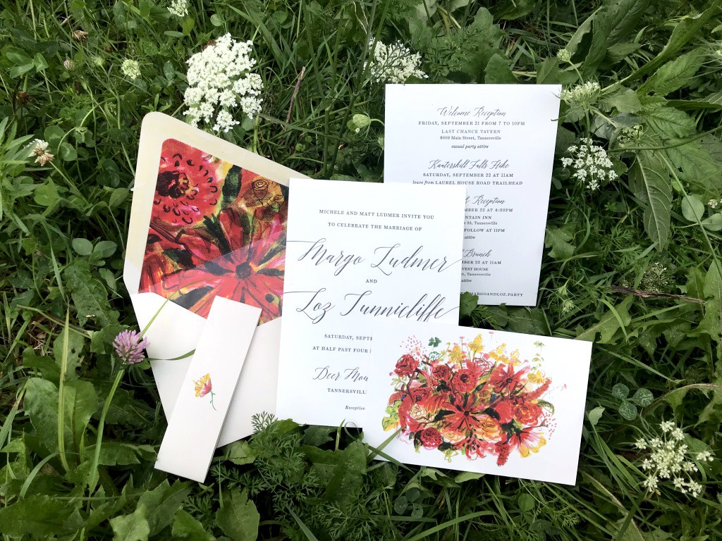 Wedding invitation suite with floral illustrations in bed of wildflowers