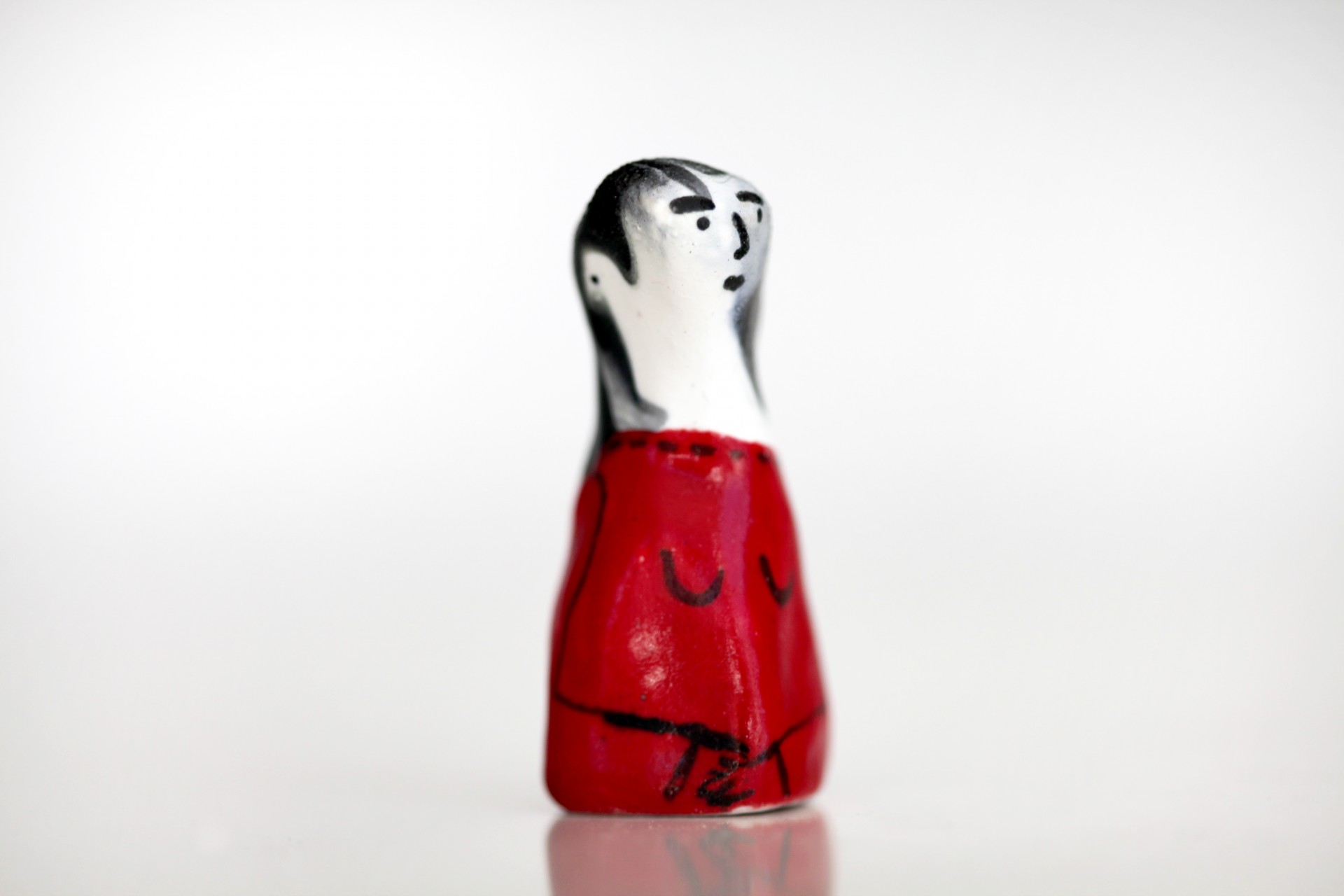 One porcelain figure with arms crossed on white background. 