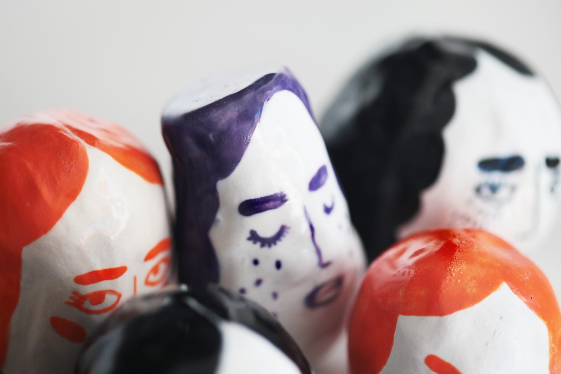 Cluster of porcelain rattles with one purple rattle in focus. 